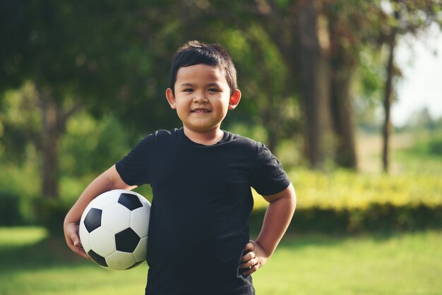 Little boy mano sosteniendo fútbol soccer