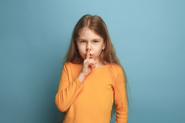 La llamada al silencio. La jovencita pidiendo silencio en un estudio azul