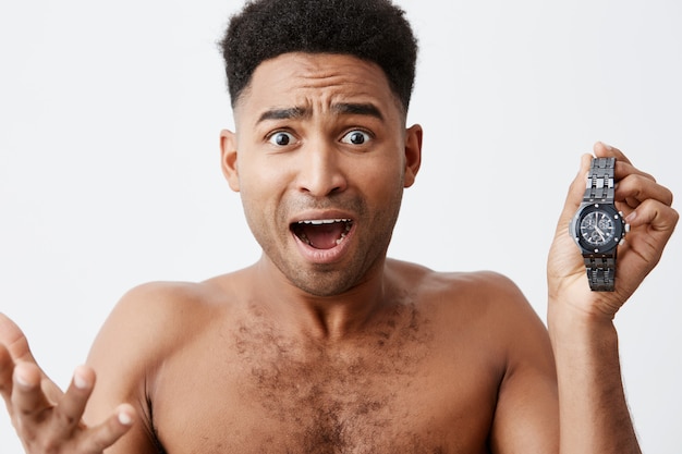 Llego tarde a la reunión. DIOS MIO. Mal comienzo del día. Atractivos y hermosos hombres africanos de piel oscura con cabello rizado se sienten frustrantes al darse cuenta de que se despertó tarde y llegó tarde al trabajo.