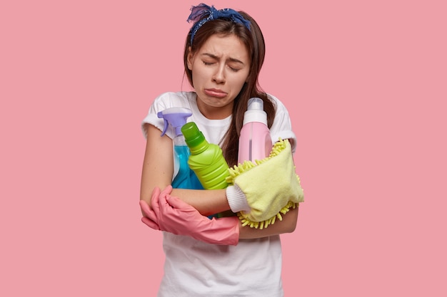 Llorando decepcionada joven cansada se siente infeliz después de la limpieza de primavera, tiene todos los suministros necesarios, detergentes, tiene una expresión facial miserable