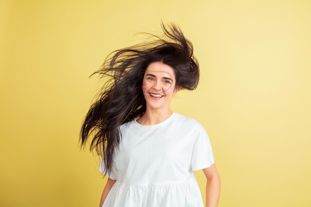 Foto gratuita locamente feliz, bailando. mujer caucásica como un conejito de pascua sobre fondo amarillo de estudio.