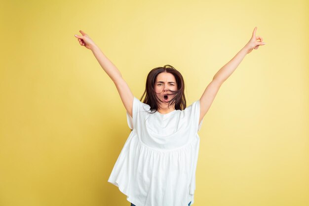 Locamente feliz, bailando. Mujer caucásica como un conejito de Pascua sobre fondo amarillo de estudio.