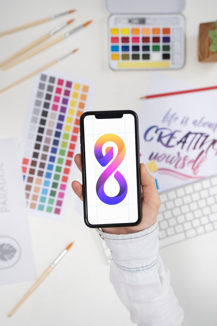 Photo Gratis logo designer holding a smartphone with a cool logo on it