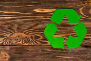 Foto gratuita logo de reciclaje eco verde sobre fondo de madera