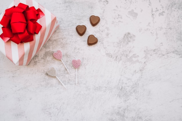 Lollipops cerca de dulces de chocolate y caja de regalo.