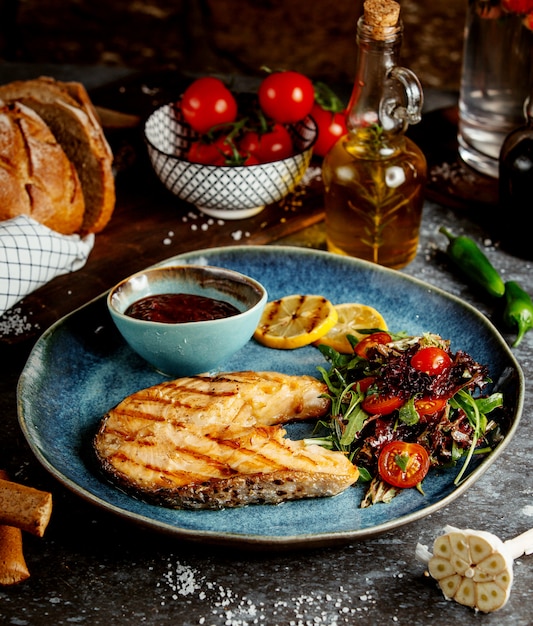 Loncha de pescado frito con hierbas y verduras y salsa