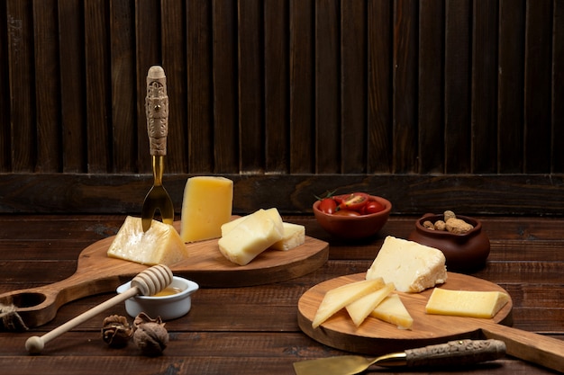 Foto gratuita lonchas de queso servidas en tableros de madera