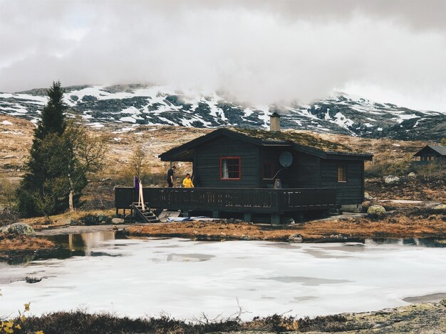 Lonely cabina se encuentra ante las montañas cubiertas de nieve