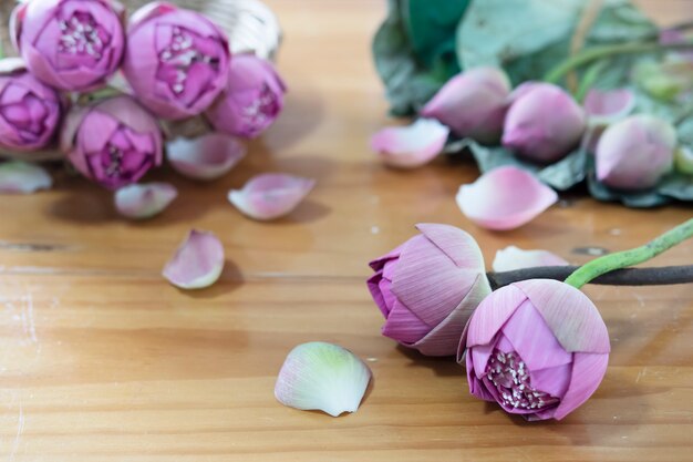 Loto rosa doblado en mesa de madera