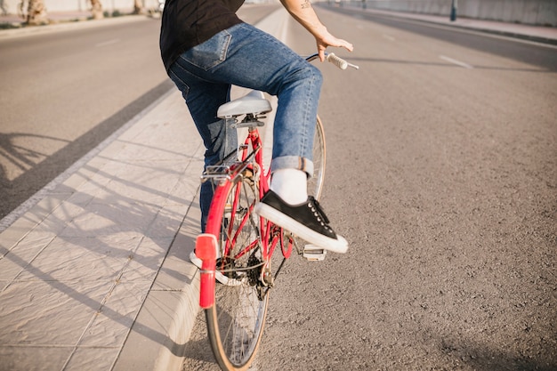 Lowsection del hombre sentado en bicicleta roja