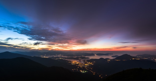 Luces de la ciudad y montañas al atardecer.