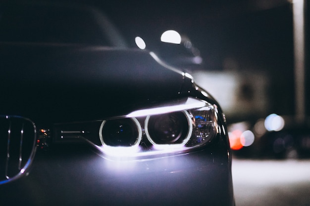 Luces delanteras del coche por la noche en la carretera