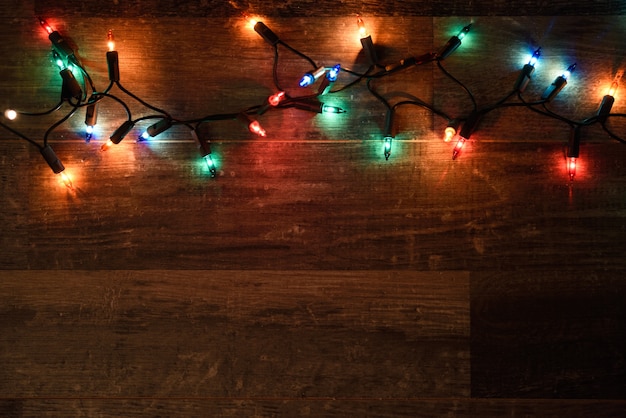 Luces de navidad en una tabla de madera oscura