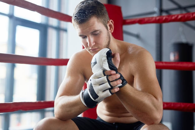 Luchador descansando en el ring de boxeo