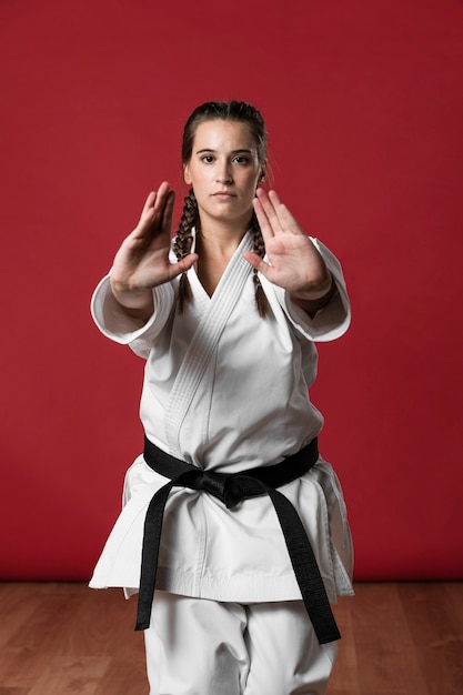 Foto gratuita luchador de karate femenino estirando las manos y mirando a cámara