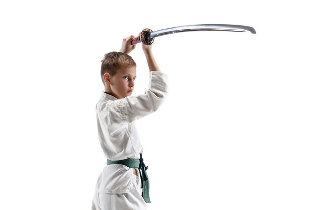 Luchador en kimono blanco con espada en pared blanca