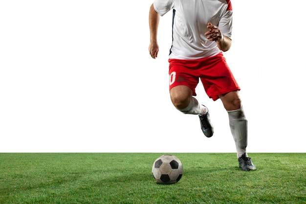 Luchando. Cerrar las piernas del fútbol profesional, jugadores de fútbol que luchan por la pelota en el campo aislado en la pared blanca. Concepto de acción, movimiento, emoción de alta tensión durante el juego. Imagen recortada.