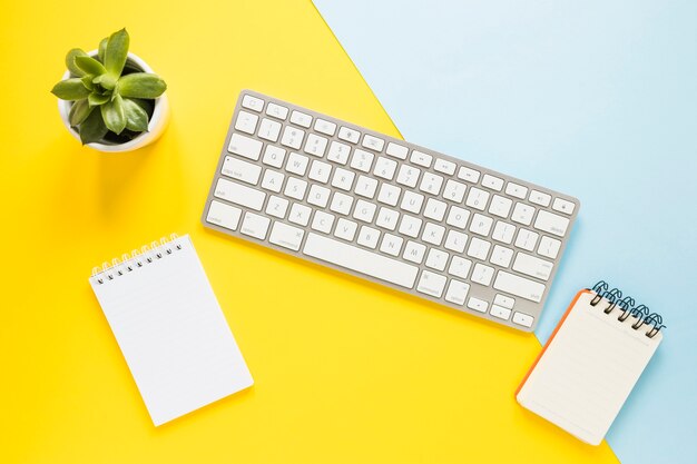 Lugar de trabajo acogedor con teclado y cuadernos