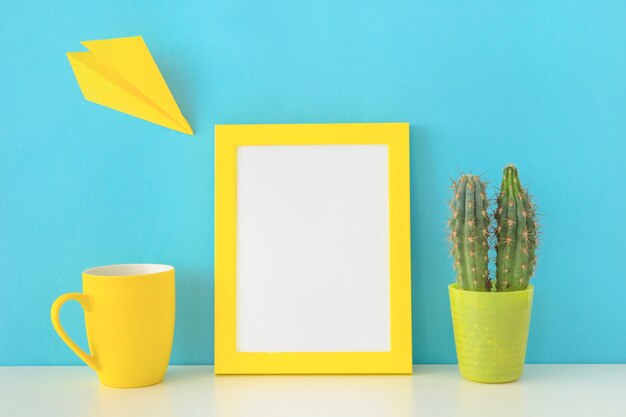 Lugar de trabajo colorido con avión de papel amarillo y cactus