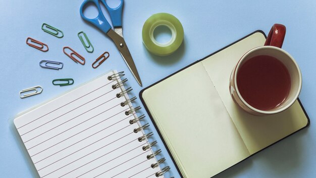 Lugar de trabajo elegante en colores azules con taza y clips