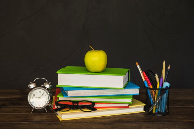 Lugar de trabajo con libros gafas despertador y papelería