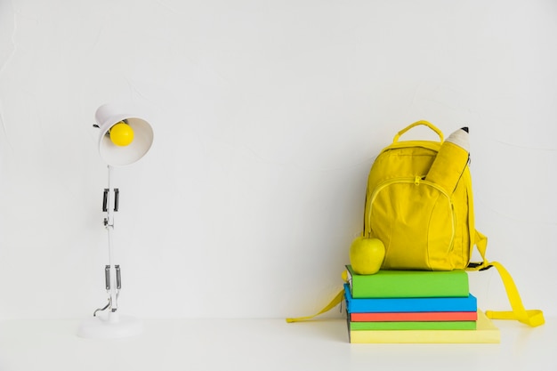 Lugar de trabajo con libros y mochila amarilla