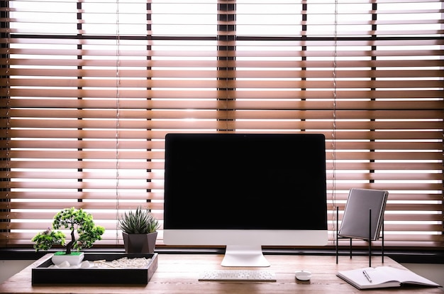 Lugar de trabajo moderno con hermoso jardín zen en miniatura y computadora en la habitación