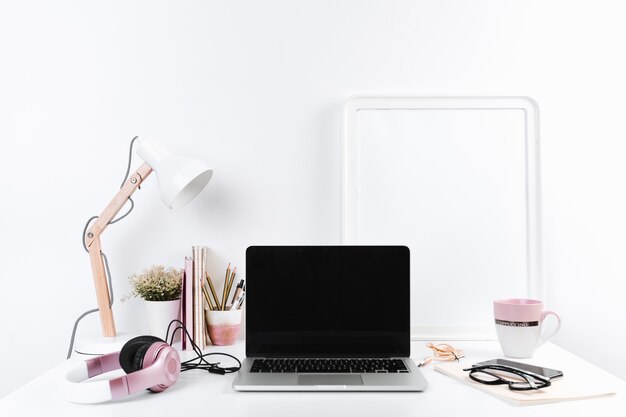 Lugar de trabajo ordenado con auriculares y efectos de escritorio del ordenador portátil