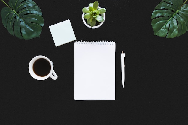 Lugar de trabajo ordenado con libreta y café