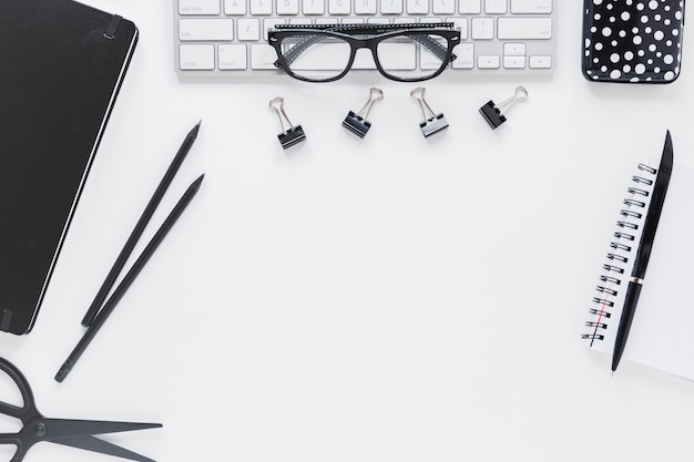 Lugar de trabajo con papelería y gafas en el teclado