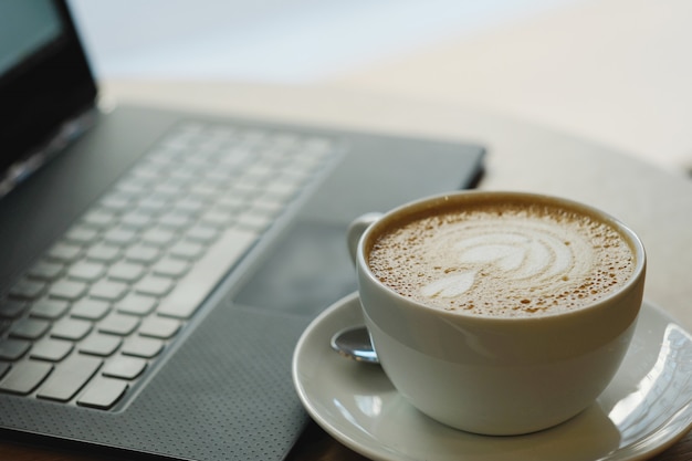 Lugar de trabajo con taza de café y computadora portátil