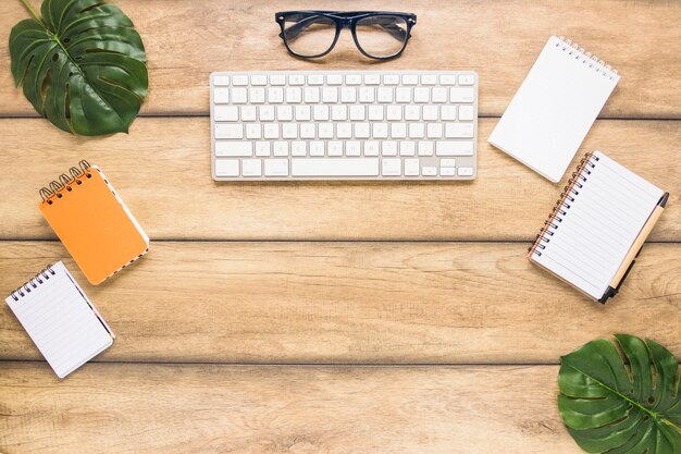 Lugar de trabajo con teclado de computadora y cuadernos