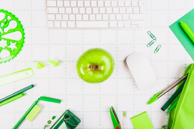 Lugar de trabajo con teclado, manzana y papelería