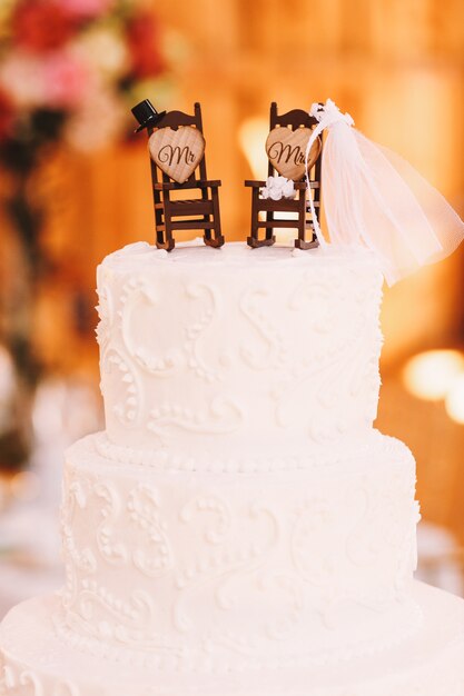 Lujoso pastel de bodas decorado con pequeñas mecedoras