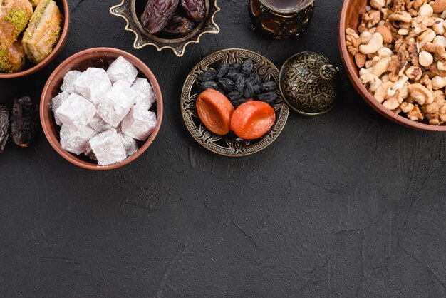 Lukum delicioso; Frutos secos y nueces sobre fondo negro con textura