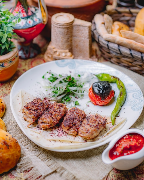 Lula kebab en lavash tomate pimiento cebolla y verduras vista lateral