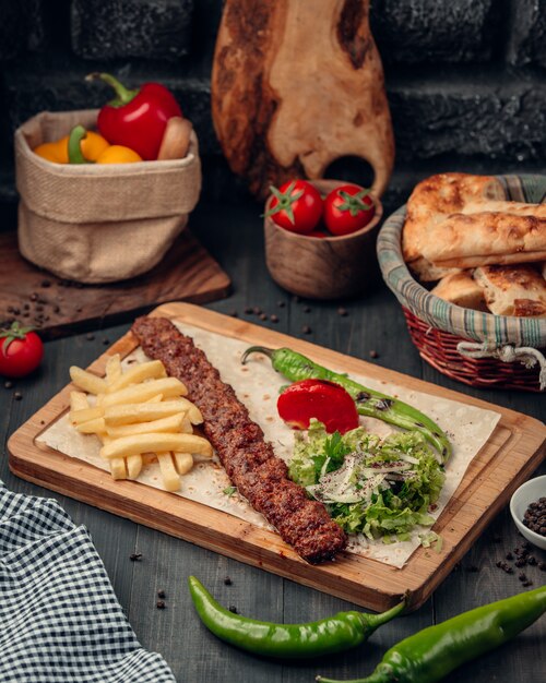 lula kebab servido con papas fritas, ensalada y pimiento asado