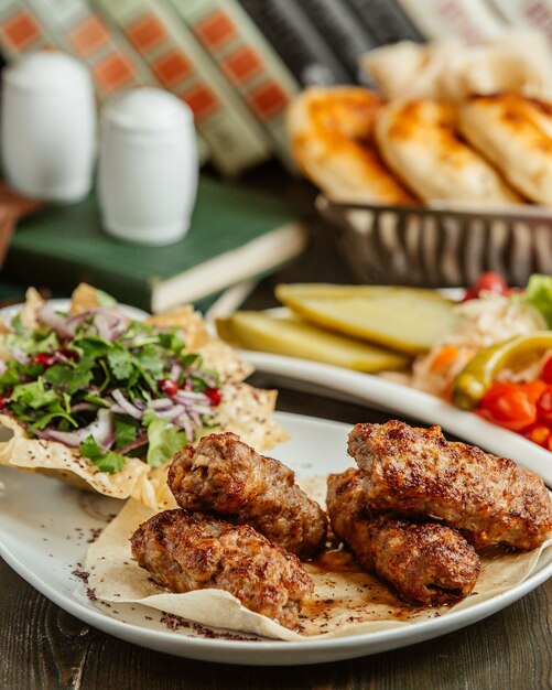 Lula kebab servido con trocitos de cebolla y verduras.