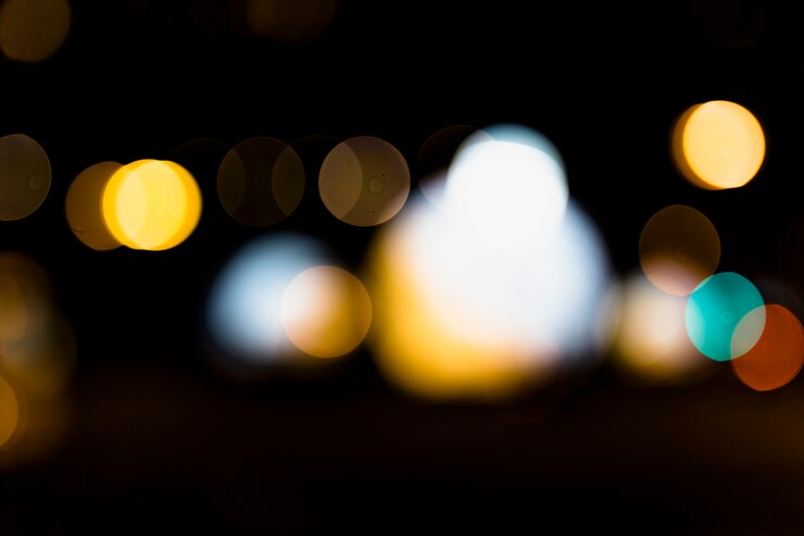Foto gratuito luz bokeh desenfocada contra un fondo negro