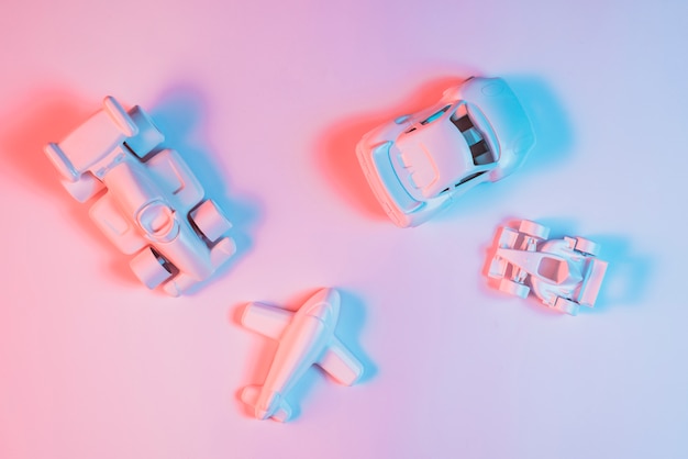 Luz de color azul en juguetes de vehículos de transporte sobre fondo rosa