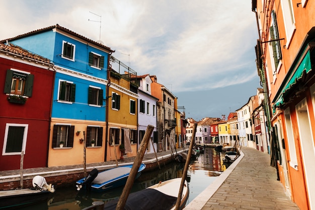 Luz hermosa del día con los barcos, los edificios y el agua. Luz de sol. Viraje. Burano, Italia.