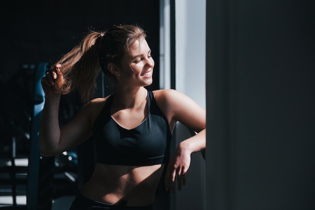 Luz del sol cálida. Hermosa mujer rubia en el gimnasio en su fin de semana