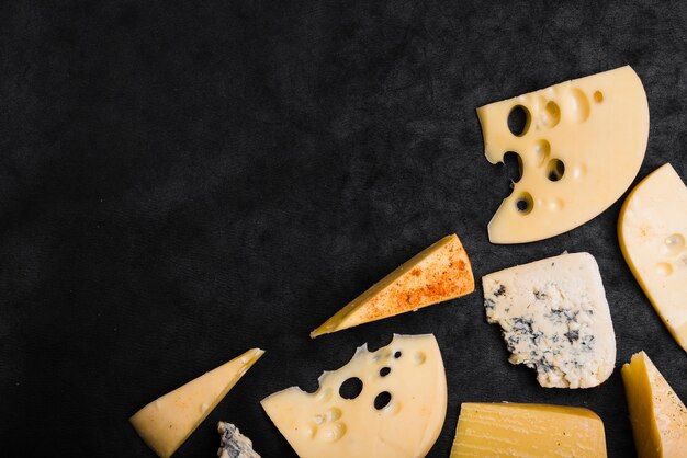 Maasdam; queso Cheddar; Gouda y queso azul sobre fondo negro