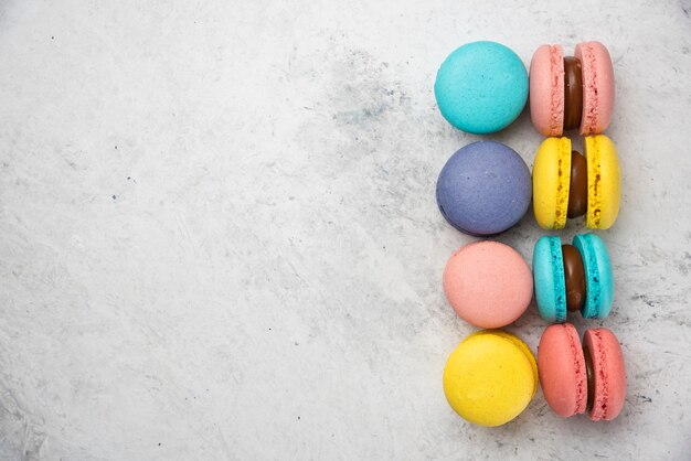 Macarons de almendras de colores sobre fondo blanco. Vista superior.