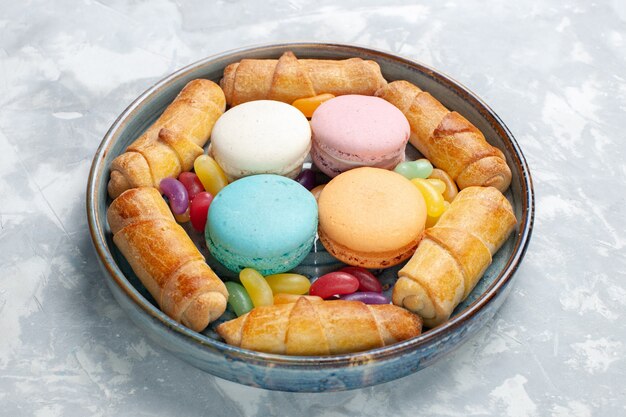 Macarons franceses de vista frontal con bagels dulces en blanco