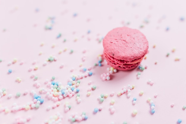 Macarrón con colores pastel asperja sobre fondo rosa