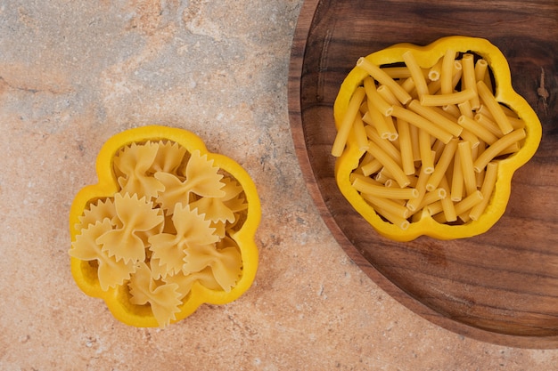 Macarrones en espiral sin cocer con pimienta sobre tabla de madera