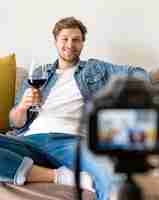 Foto gratuita macho adulto grabándose a sí mismo con una copa de vino