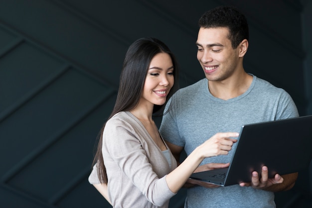 Macho adulto y mujer trabajando juntos en una computadora portátil