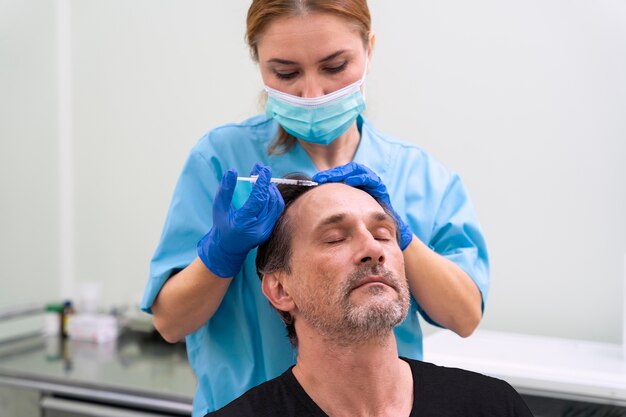 Macho adulto recibiendo un tratamiento para la caída del cabello